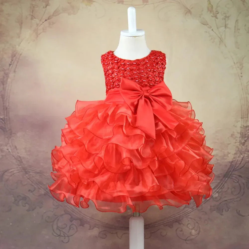 Red beaded special occasion dress for girls with ruffled skirt and large bow on mannequin