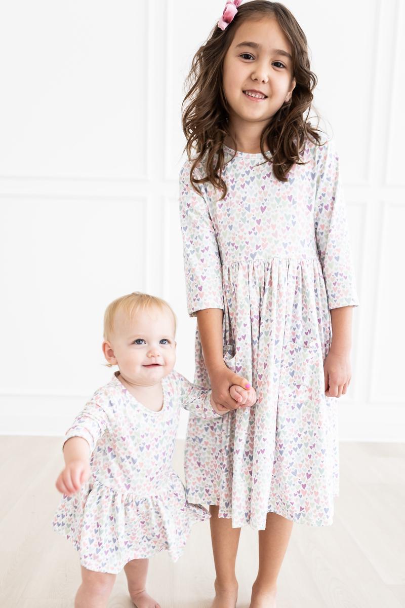 One in a Million 3/4 Sleeve Twirl Bodysuit modeled by two adorable girls, showcasing the twirl design perfect for spinning and fun.