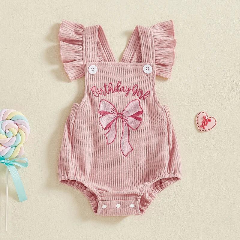 Pink baby girl birthday romper with ruffle shoulder straps and embroidered bow for infants