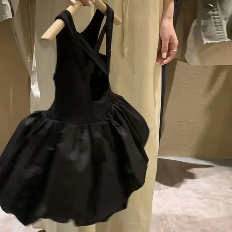 black girls party dress with cutouts hanging on wooden hanger held by person