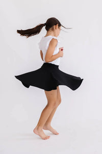 young girl twirling in black twirl skort for girls by Mila & Rose in a white sleeveless top