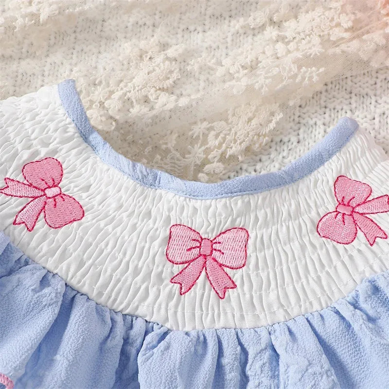 Blue embroidered baby bubble romper for infants with pink bow details on white smocked collar