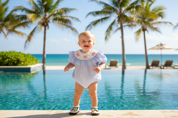 blue embroidered baby bubble romper with puff sleeves and pink bow details for infants