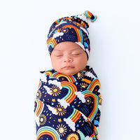 The SoftKnot Cap Here Comes the Sunshine (Blue): bamboo newborn hat with rainbow sun, clouds and knot top.
