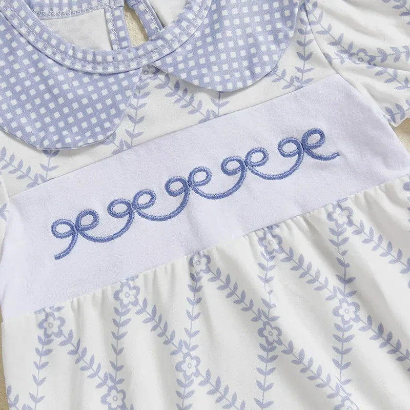 baby blue romper with white floral pattern and embroidered bow detail with peter pan collar