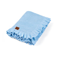 Folded light blue knit baby blanket with ruffled edge and brown brand tag on white background