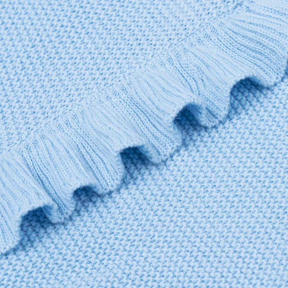 Macro detail of soft cotton knit weave and structured wavy ruffled hem texture