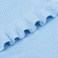 Macro detail of soft cotton knit weave and structured wavy ruffled hem texture