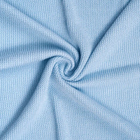Spiral swirl of light blue knitted fabric highlighting fine weave pattern and flexibility