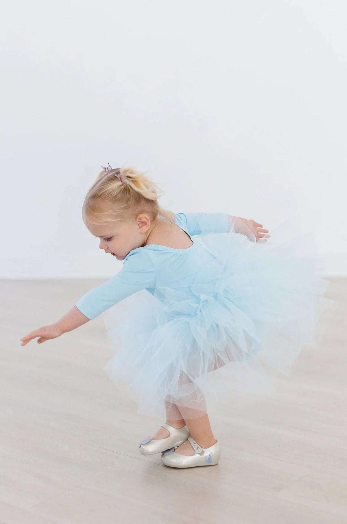 Toddler girl wearing blue tutu leotard for girls with 3 quarter sleeves and fluffy tulle skirt