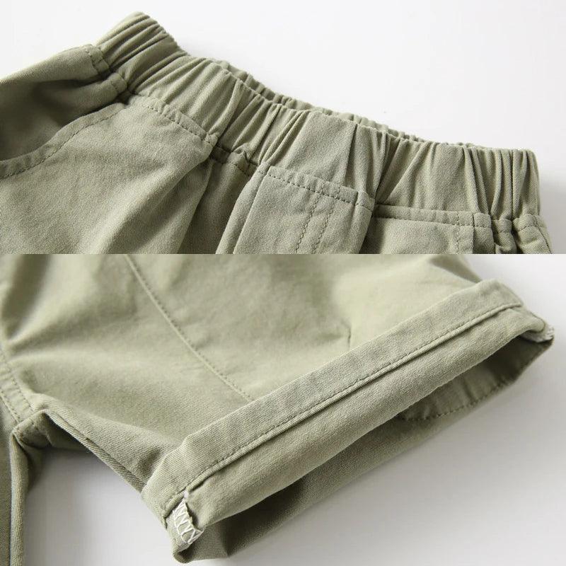 close up of olive green boys cargo shorts with pockets showing elastic waistband and cuffed hem