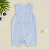 light blue striped boys golf romper for infants laid flat on beige surface with sunglasses and leaf