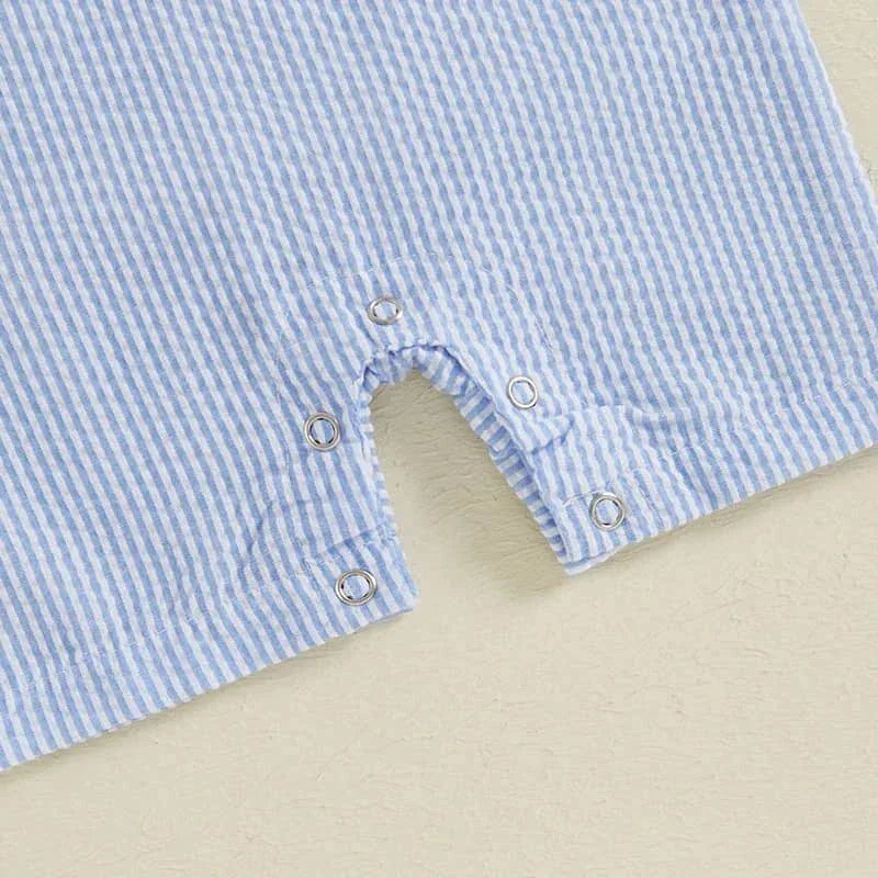 Close-up of light blue and white striped boys golf romper with snap buttons for easy diaper changes