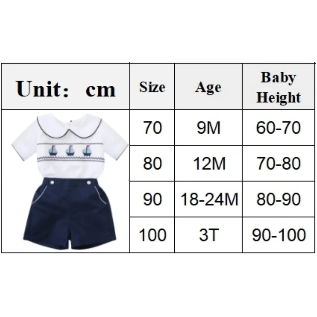 White cotton boys smocked sailboat outfit with navy blue shorts for babies and kids