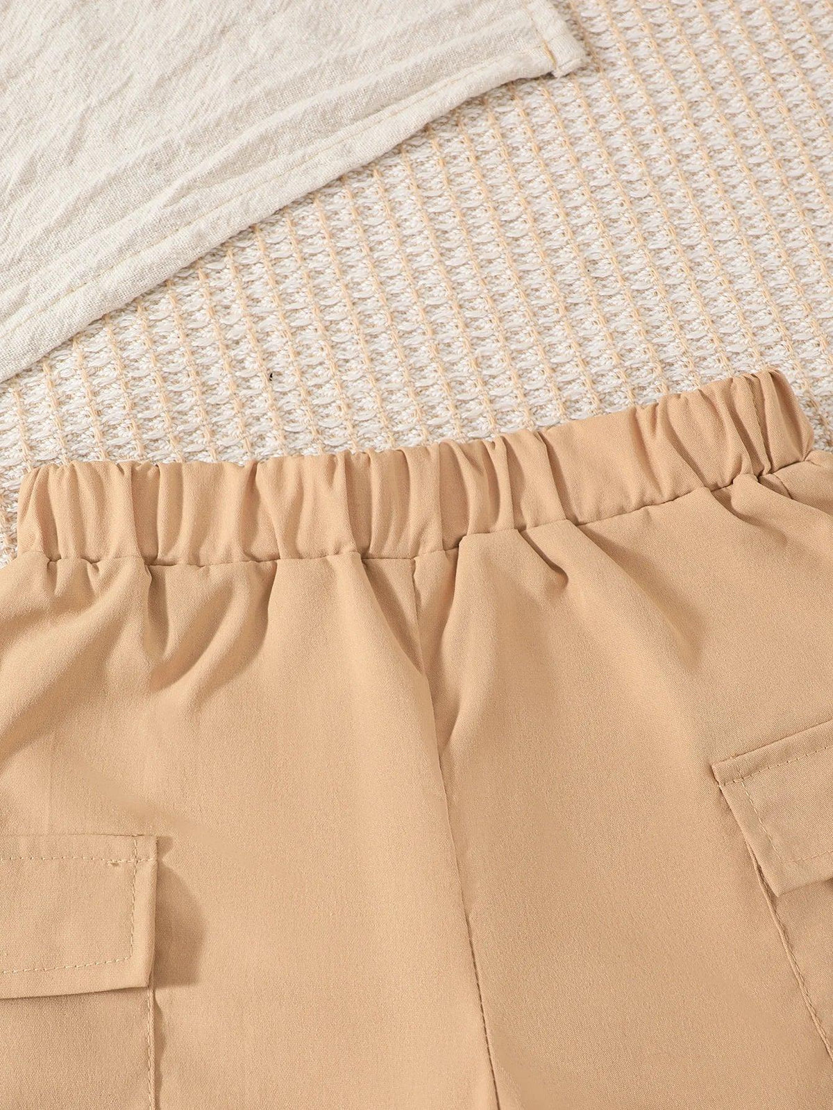 Close-up of beige boys striped shorts outfit set showing elastic waistband and pocket details for toddlers