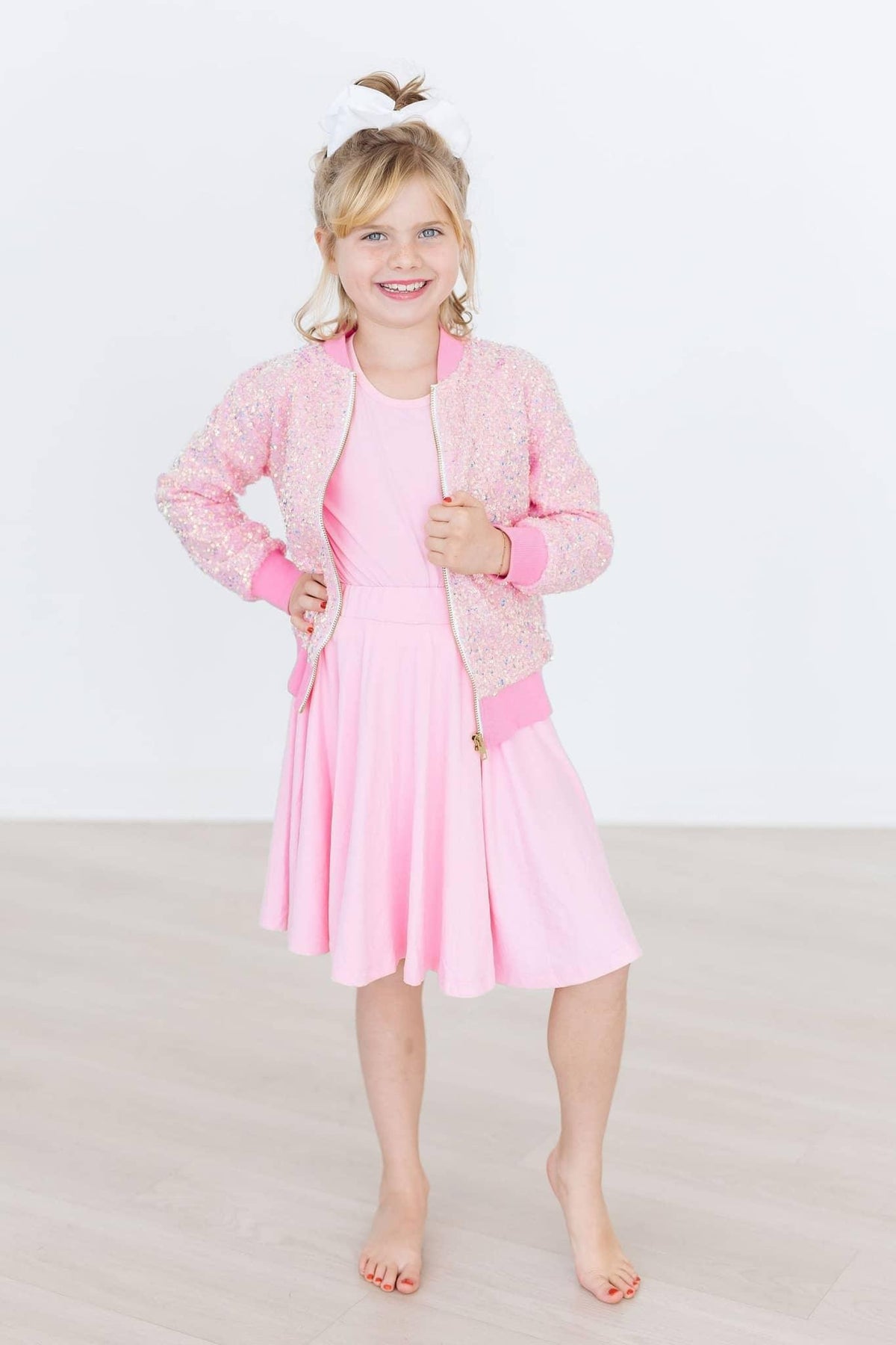 Girl wearing bubblegum pink twirl skort for girls standing barefoot with hands on hips smiling