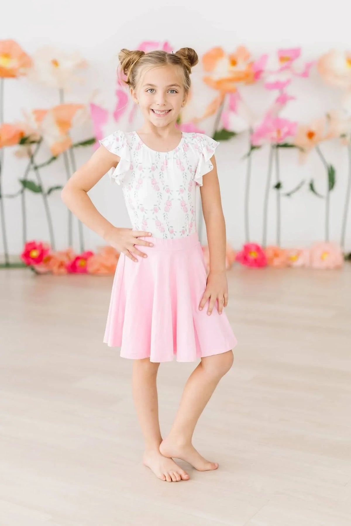 Young girl wearing bubblegum pink twirl skort for girls standing and smiling indoors
