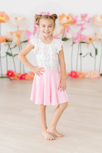 Young girl wearing bubblegum pink twirl skort for girls standing and smiling indoors
