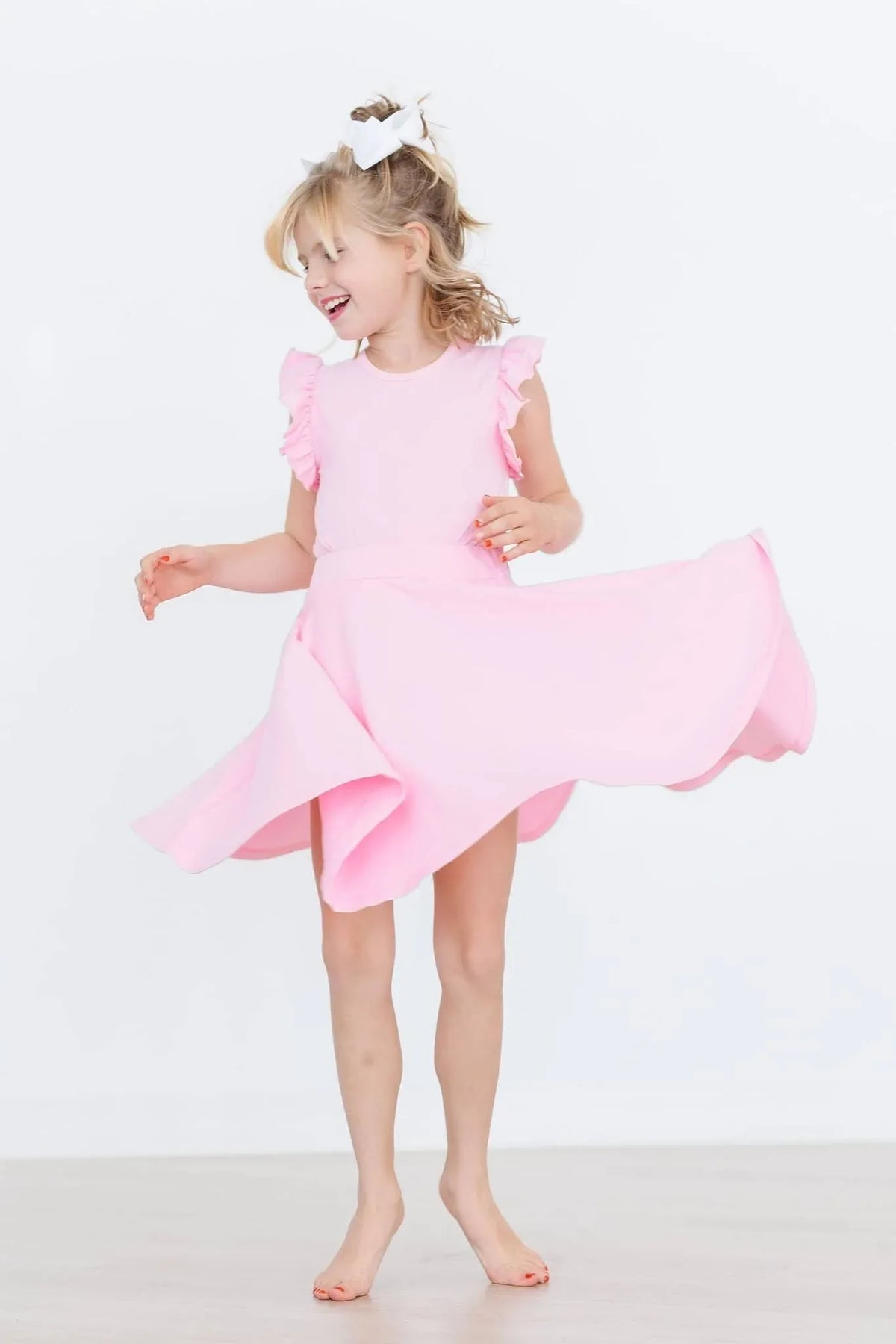 Young girl twirling in a bubblegum pink twirl skort for girls from Mila and Rose