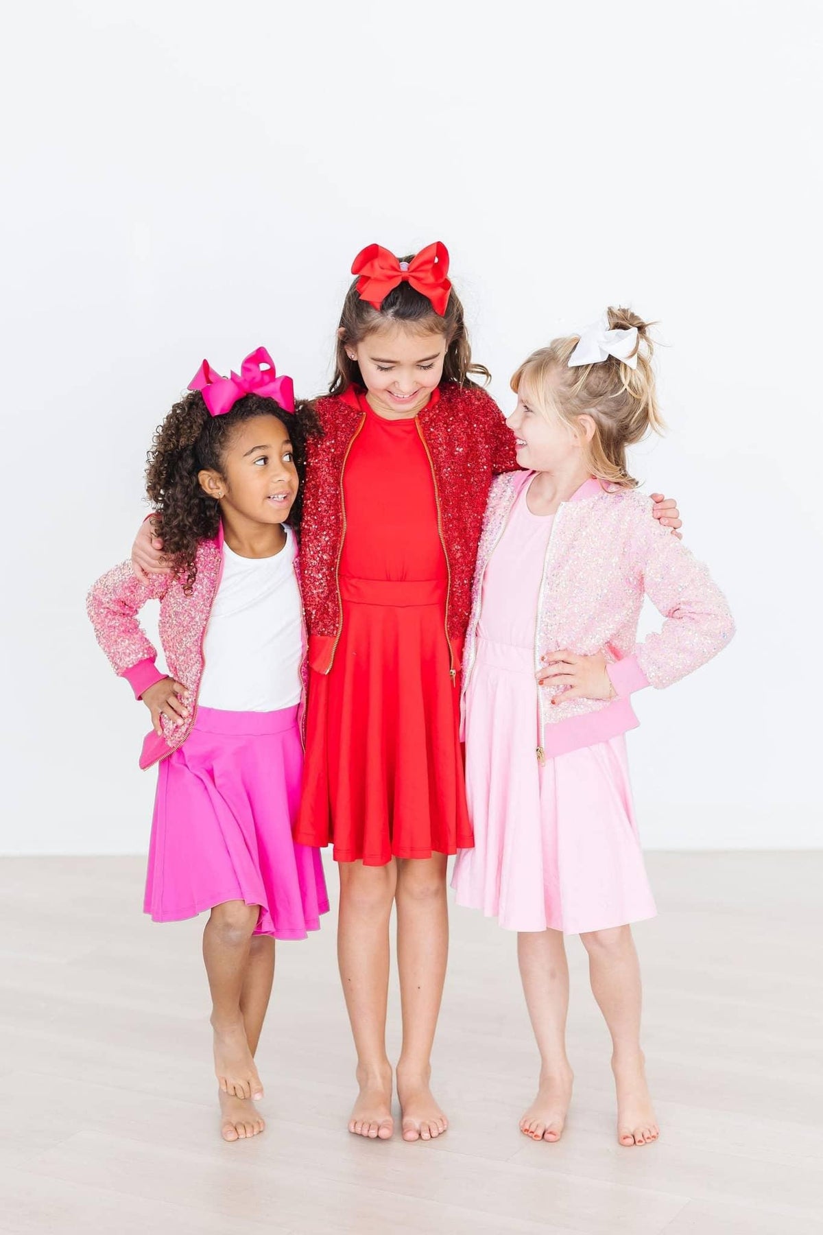 Girl wearing bubblegum pink twirl skort for girls standing with two friends smiling and posing