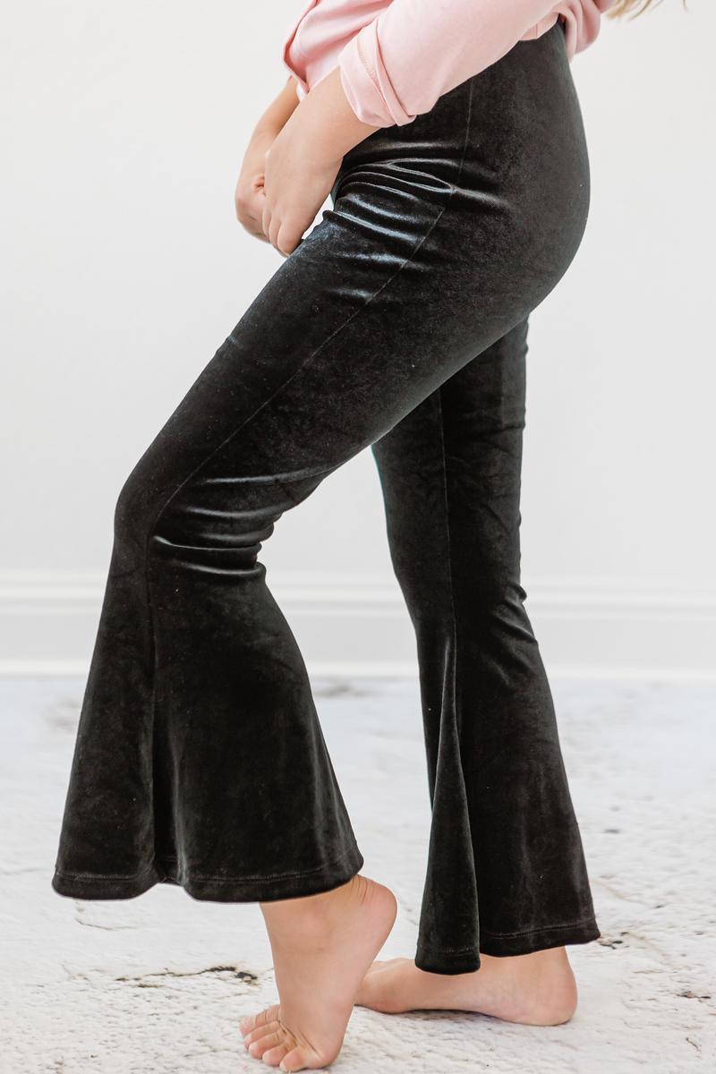 A child wearing Black Velvet Bells, showcasing a high-waisted design with flared bottoms, perfect for a stylish and comfortable look. Ideal for various occasions.