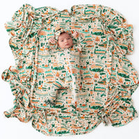 A cheerful baby wrapped in The Forever Large Swaddle Blanket, demonstrating the comfort and versatility of this large swaddle blanket.