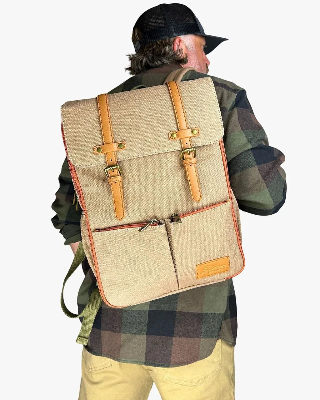 Man in plaid shirt wearing beige Bon Secour diaper backpack demonstrating stylish fit for active parenting