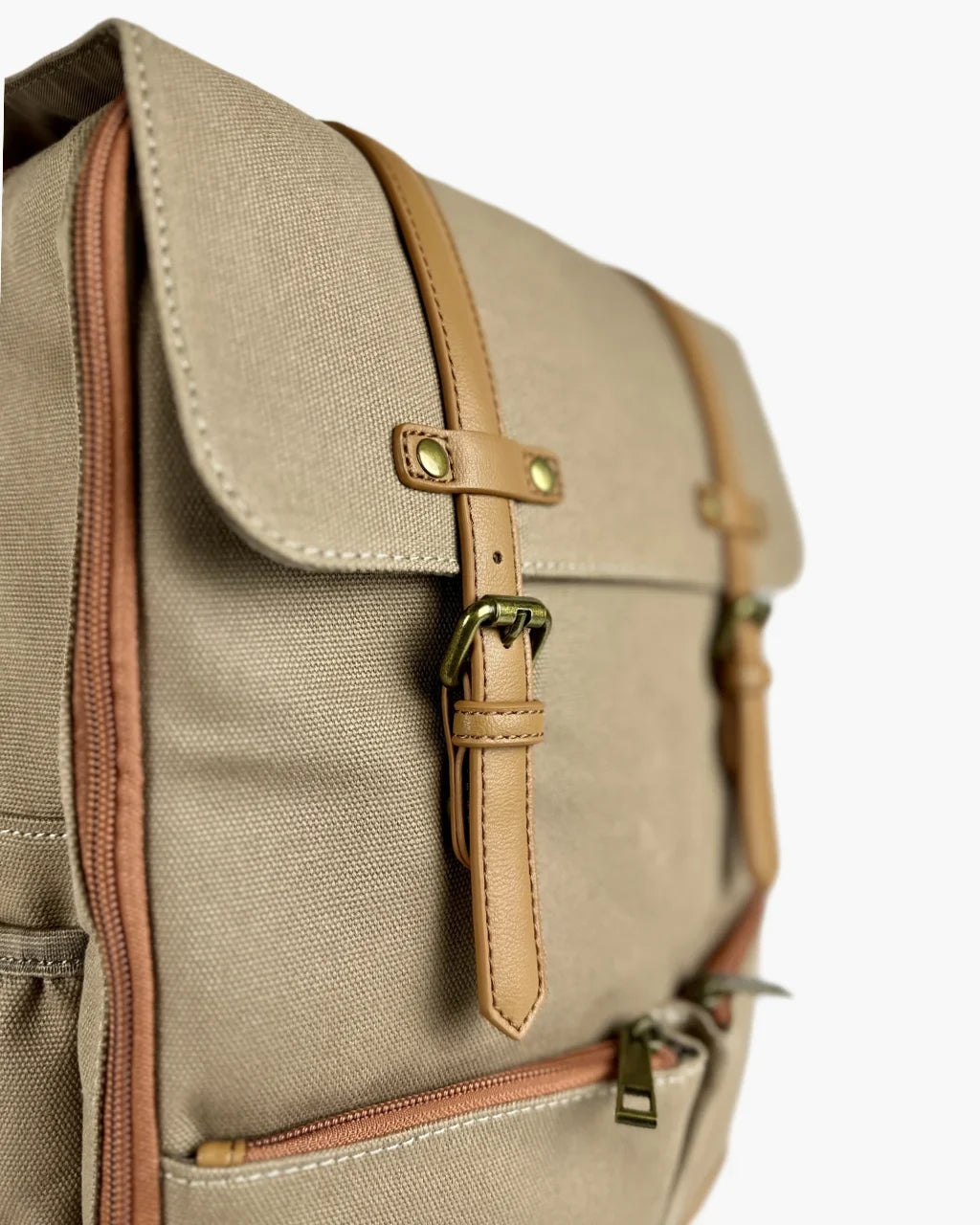 Close-up of tan leather strap detail, antique brass buckle hardware, and durable woven texture of beige canvas fabric