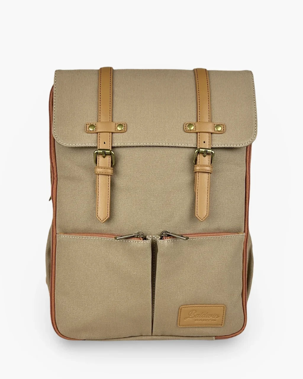 Beige rugged canvas diaper backpack with tan leather straps, brass buckles, and rust zipper trim on front pocket