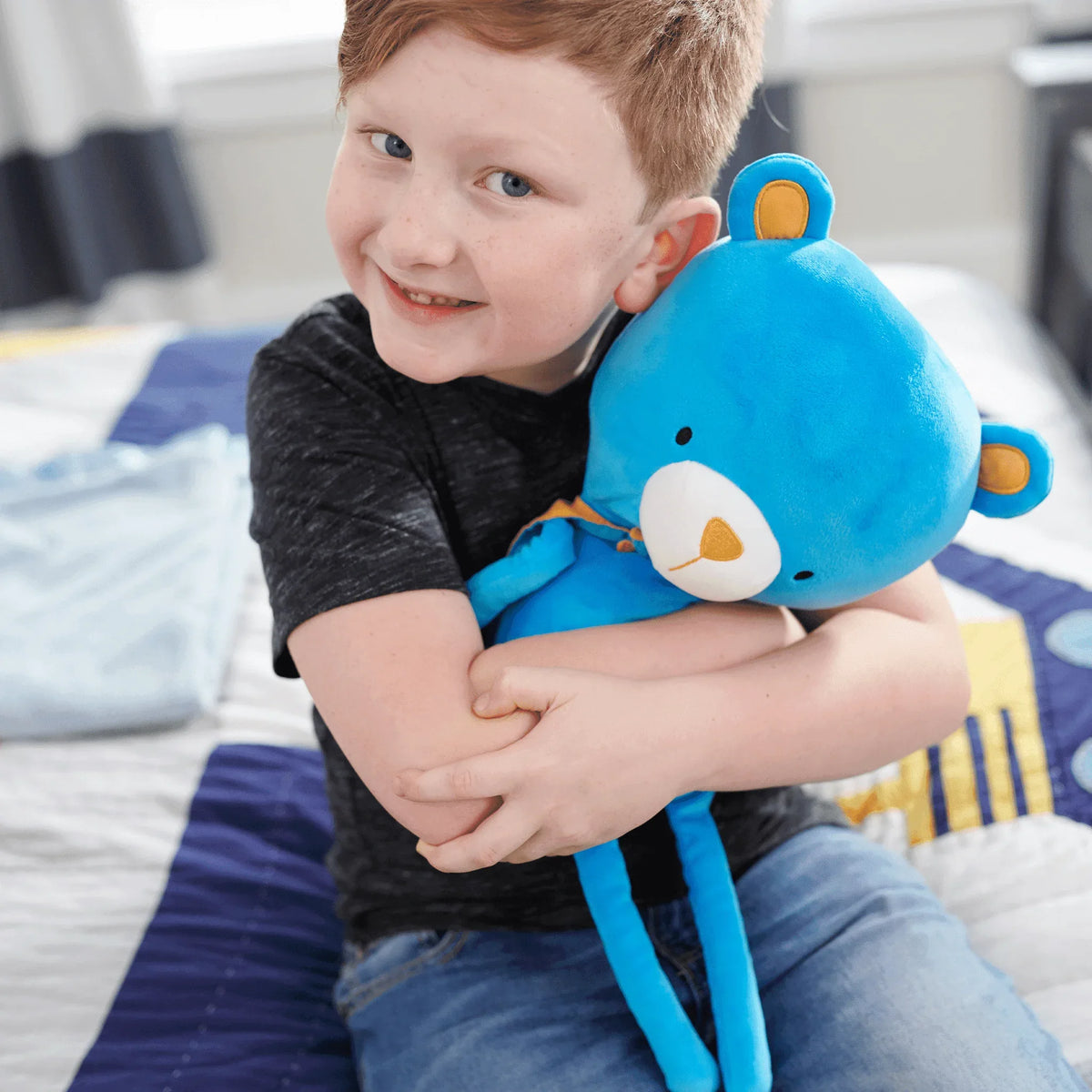 Blue cape bear plush doll for toddlers made of soft plush material held by smiling toddler boy