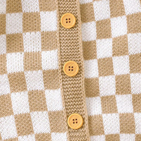 tan and white checkered baby romper with wooden buttons close-up knit fabric detail