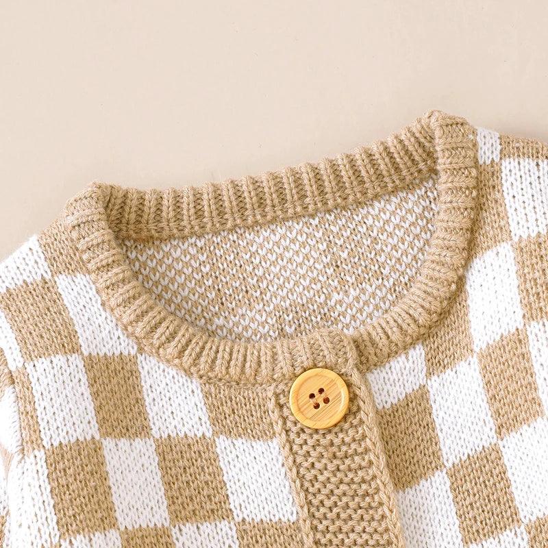 beige and white checkered baby romper with wooden button closure knitted fabric