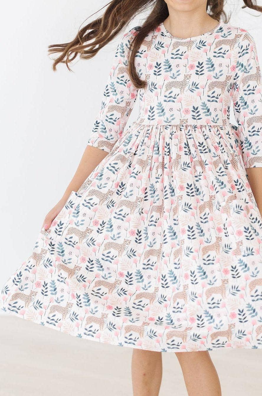 young girl wearing Mila & Rose cheetah twirl dress for girls holding dress out while twirling