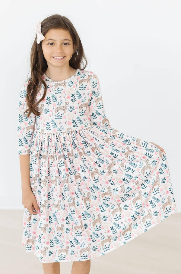 Girl wearing Mila & Rose cheetah twirl dress for girls with 3/4 sleeves holding dress out to twirl