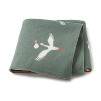green children's knit blanket with white stork carrying a bundle design for babies and kids