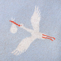 Blue children's knit blanket with white stork carrying bundle design for babies and kids