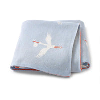 Light blue children's knit blanket with white stork design and red trim for babies and kids