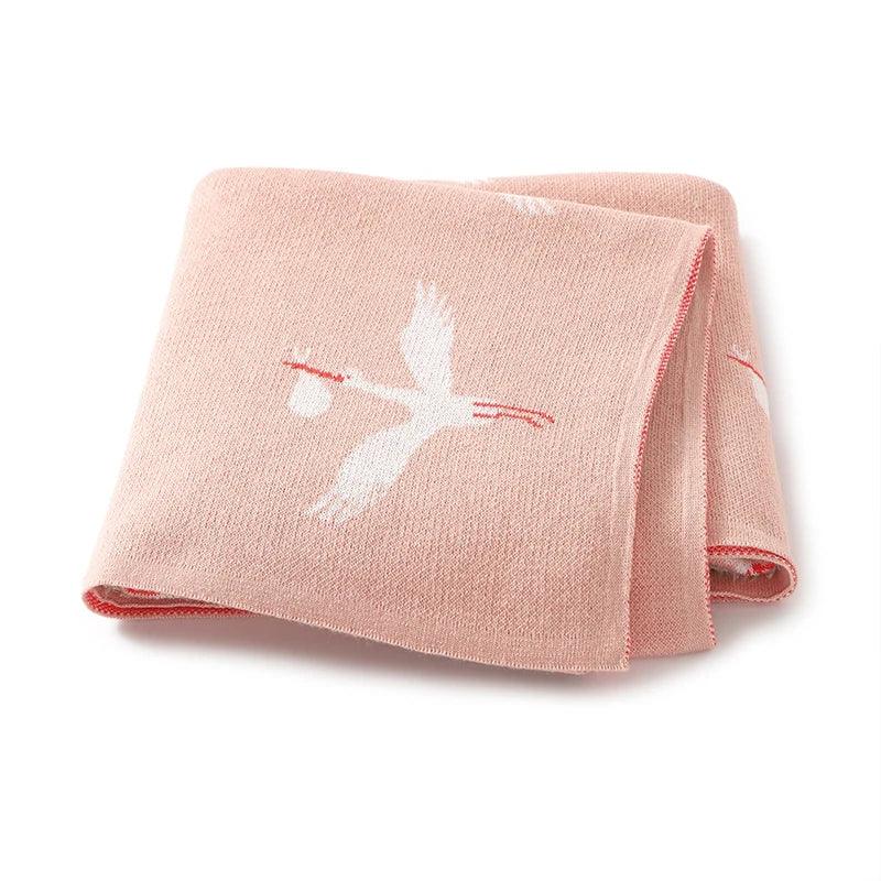 pink children's knit blanket with white stork design for babies and toddlers