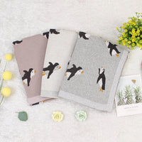 Childrens knit penguin blanket in gray, beige, and pink colors, perfect for babies and kids