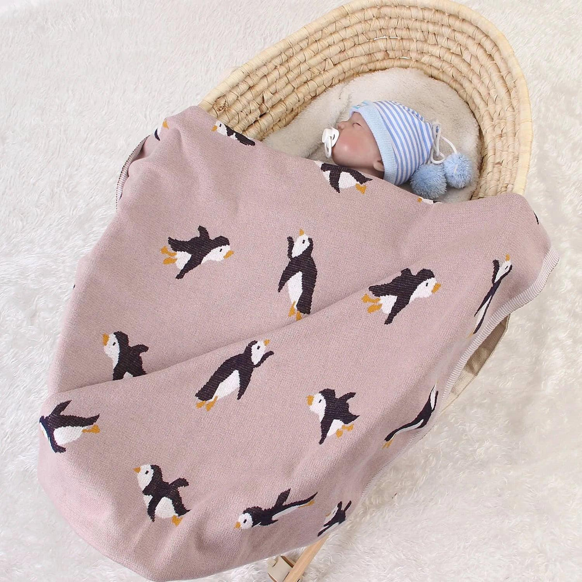 childrens knit penguin blanket in soft pink with black and white penguin pattern, suitable for babies