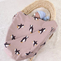 childrens knit penguin blanket in soft pink with black and white penguin pattern, suitable for babies