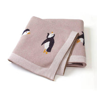 Childrens knit penguin blanket in soft pink with black and white penguin design for babies and kids