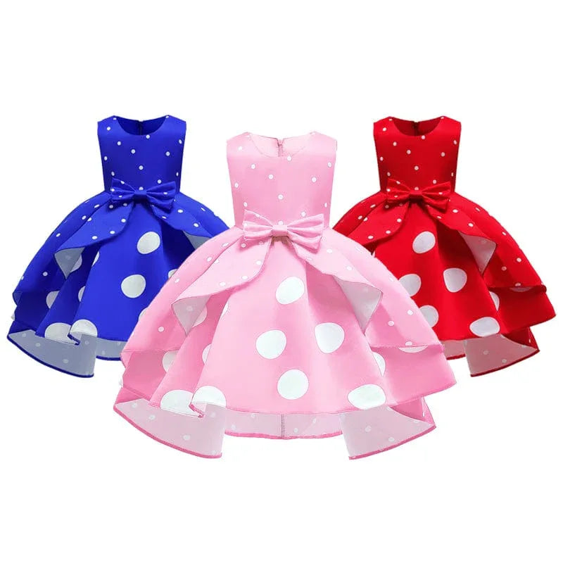 Girls sleeveless childrens party dress in blue pink and red with large white polka dots and bow detail