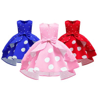 Girls sleeveless childrens party dress in blue pink and red with large white polka dots and bow detail