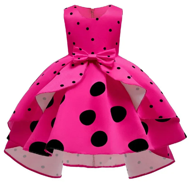 Girls bright pink childrens party dress with black polka dots and a front bow detail
