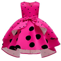 Girls bright pink childrens party dress with black polka dots and a front bow detail