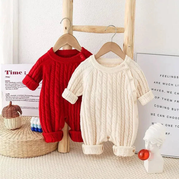 Red and cream classic cable knit baby romper for infants hanging on wooden ladder