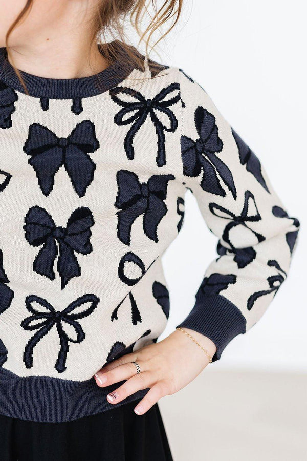 Women's cream and black knit sweater with bow pattern and long sleeves by Mila & Rose
