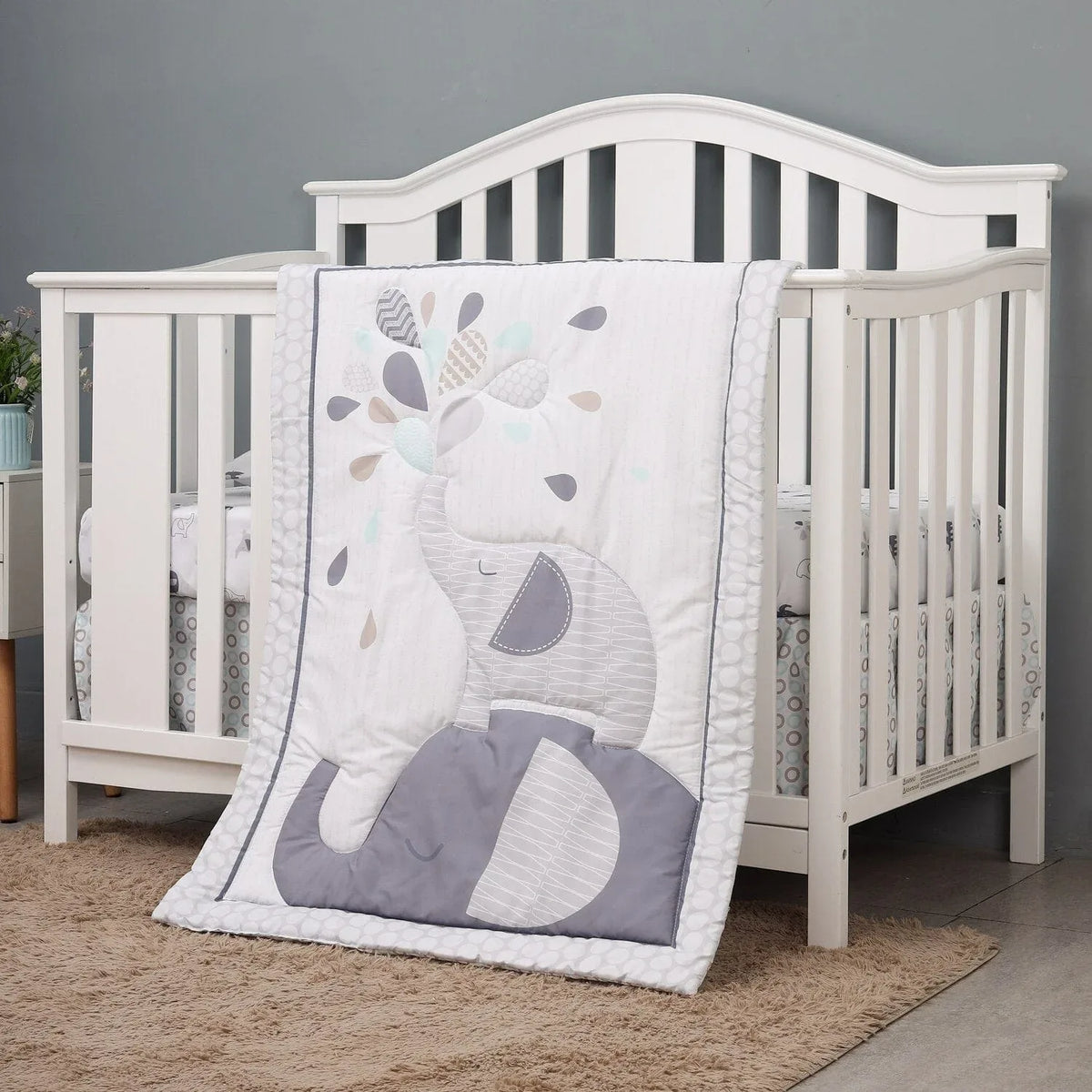 White and gray baby crib comfort set with elephant design, suitable for infants, includes quilt and bedding