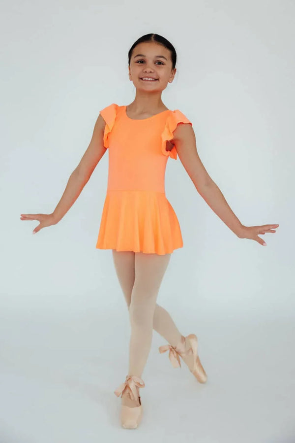 Young girl wearing coral girls short sleeve twirl leotard standing in ballet pose